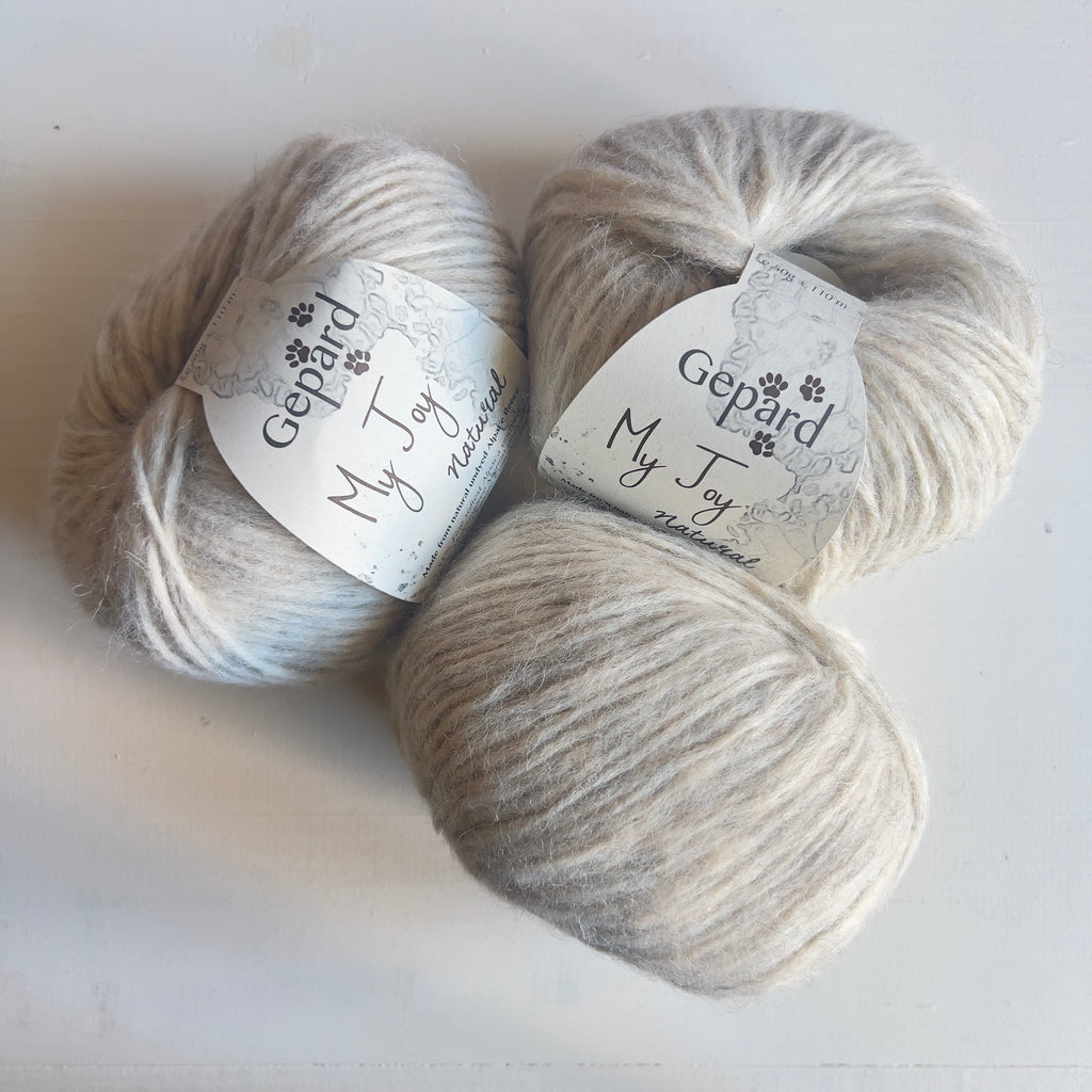 Three balls of Gepard My Joy yarn in 103 Nordic Snow, a soft off-white shade
