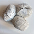 Three balls of Gepard My Joy yarn in 103 Nordic Snow, a soft off-white shade
